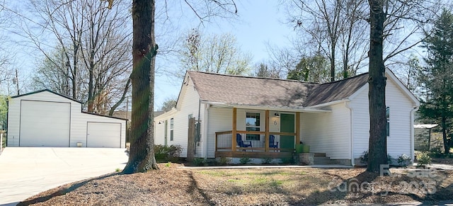 view of front of home with an outbuilding, roof with shingles, covered porch, concrete driveway, and a garage