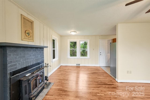 110 Maplewood Knoll Dr, East Flat Rock, NC 28726 - unfurnished living room with visible vents, baseboards, ceiling fan, and light wood-style floors
