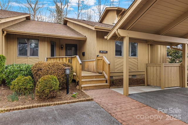 entrance to property featuring crawl space, roof with shingles, and a porch