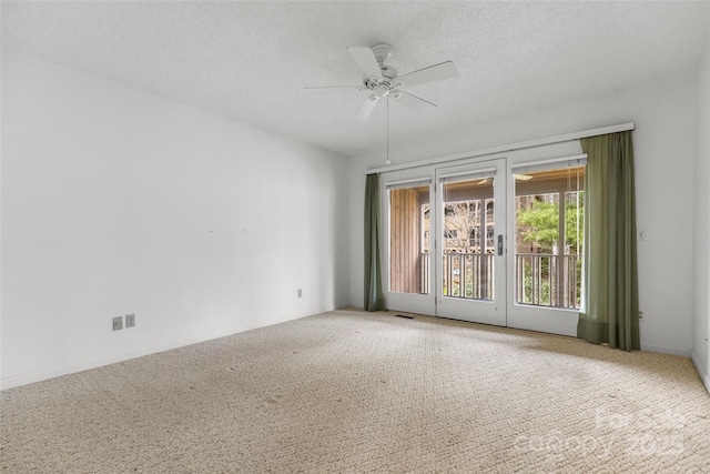 empty room featuring carpet flooring, visible vents, a textured ceiling, and a ceiling fan