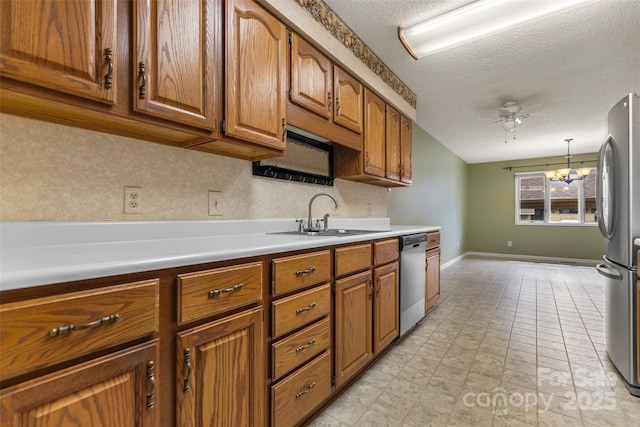 kitchen featuring a sink, ceiling fan with notable chandelier, brown cabinets, and stainless steel appliances