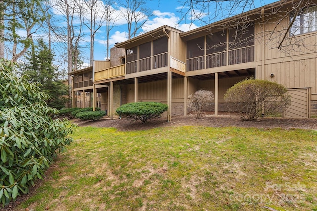 back of property featuring a yard and a sunroom