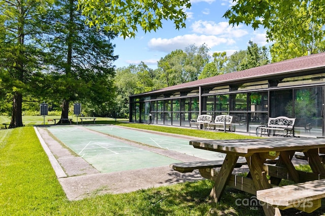 view of home's community with shuffleboard and a lawn