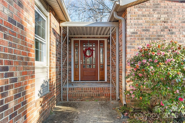 view of exterior entry featuring brick siding