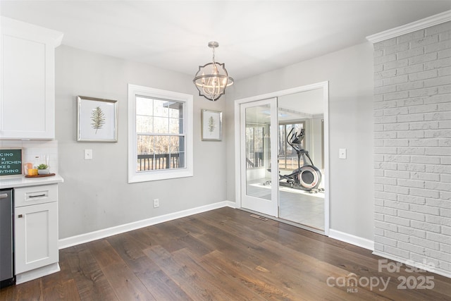 unfurnished dining area with dark wood-style floors, a chandelier, visible vents, and baseboards