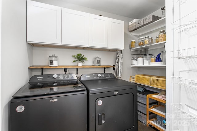 clothes washing area featuring cabinet space and independent washer and dryer