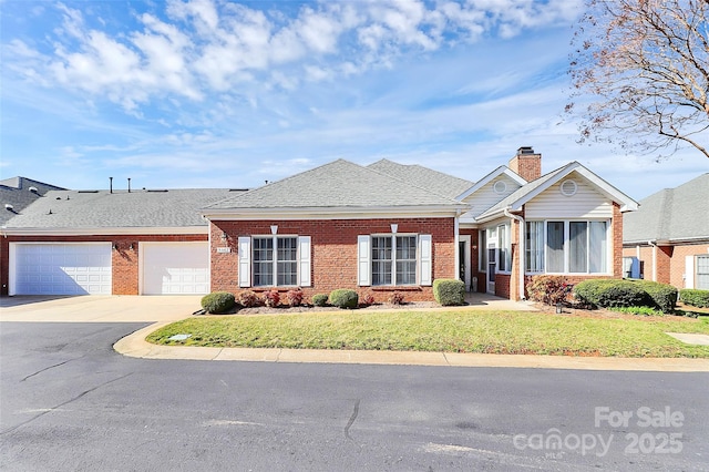 view of front of property with brick siding, a garage, concrete driveway, and a front lawn