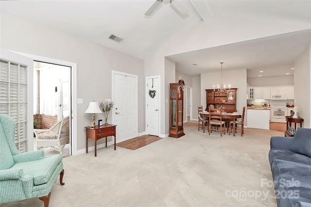 living area featuring baseboards, light carpet, beam ceiling, and ceiling fan with notable chandelier