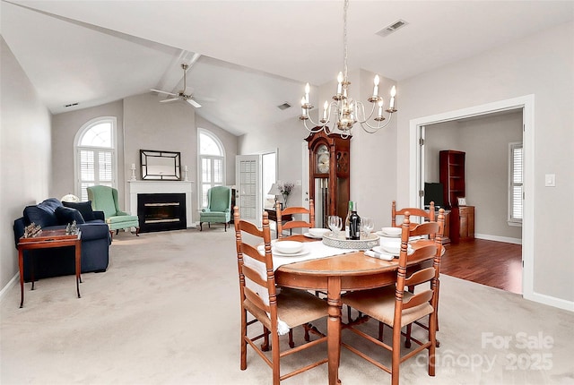 dining room featuring light carpet, visible vents, ceiling fan with notable chandelier, and lofted ceiling with beams