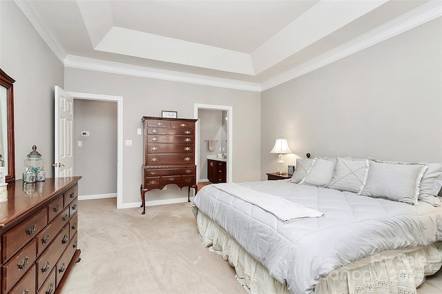 bedroom with a raised ceiling, baseboards, ensuite bathroom, and light carpet