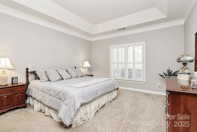 bedroom featuring light carpet, visible vents, baseboards, and a tray ceiling