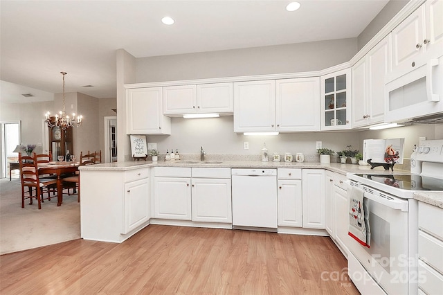 kitchen featuring white appliances, a notable chandelier, and white cabinets