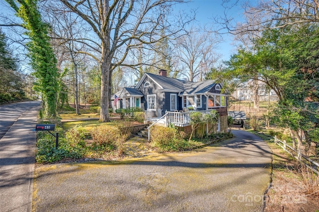 view of front facade with aphalt driveway and a chimney