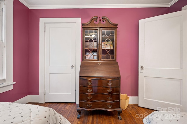 bedroom featuring ornamental molding, baseboards, and wood finished floors