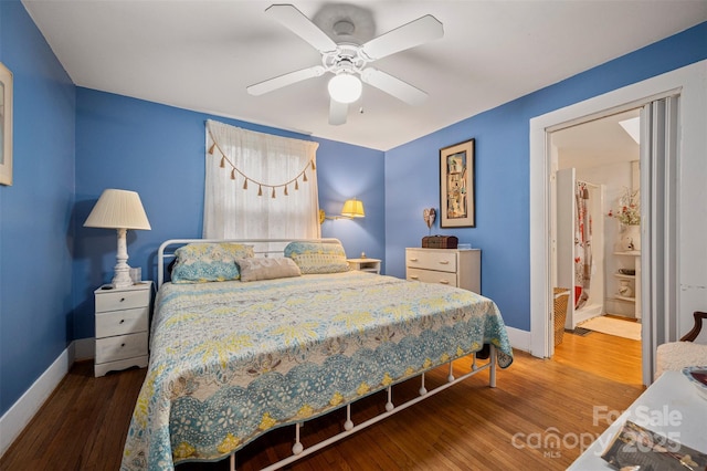 bedroom with baseboards, wood finished floors, and a ceiling fan