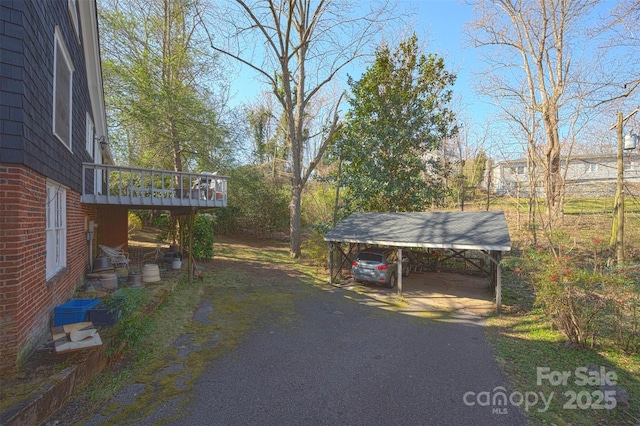 view of yard featuring a carport and driveway