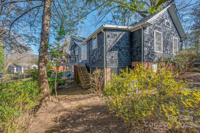 view of side of home with stairs and a wooden deck