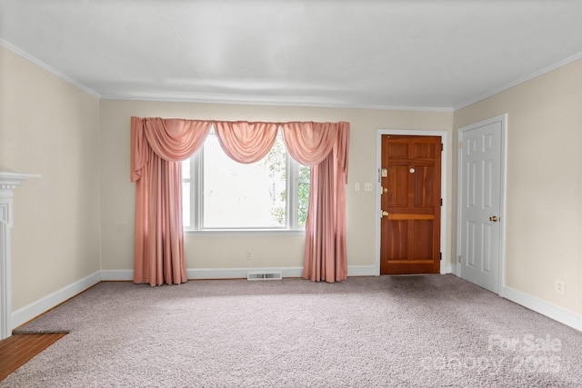 carpeted empty room with visible vents, baseboards, and crown molding