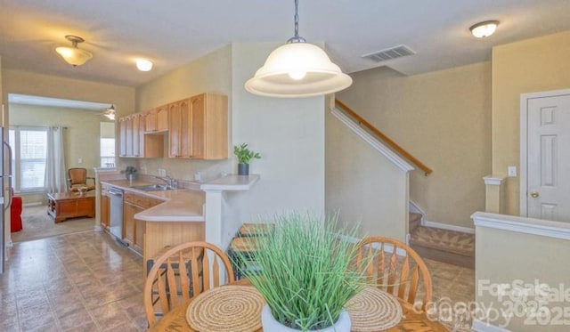 kitchen featuring visible vents, light brown cabinets, dishwasher, light countertops, and a sink