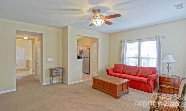 living room featuring light colored carpet, baseboards, visible vents, and ceiling fan