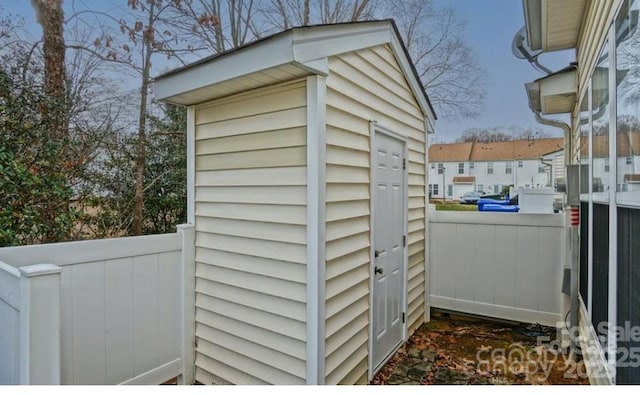 view of shed featuring fence