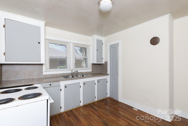 kitchen featuring white range with electric cooktop, a sink, dark wood finished floors, light countertops, and decorative backsplash