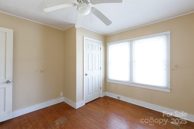 unfurnished bedroom featuring ornamental molding, a ceiling fan, baseboards, and wood finished floors