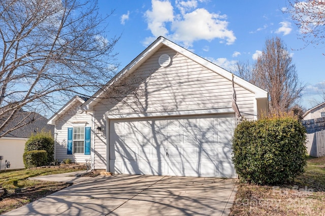 exterior space with an attached garage, fence, and driveway