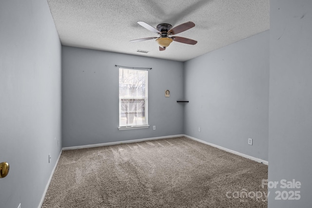 carpeted spare room with visible vents, baseboards, a textured ceiling, and ceiling fan