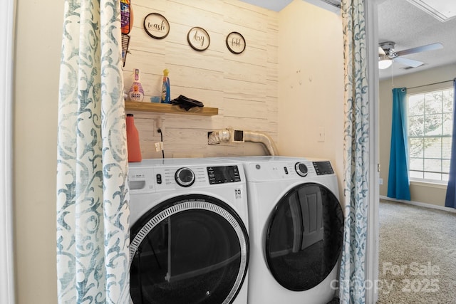 clothes washing area featuring a ceiling fan, carpet, wood walls, laundry area, and washing machine and clothes dryer