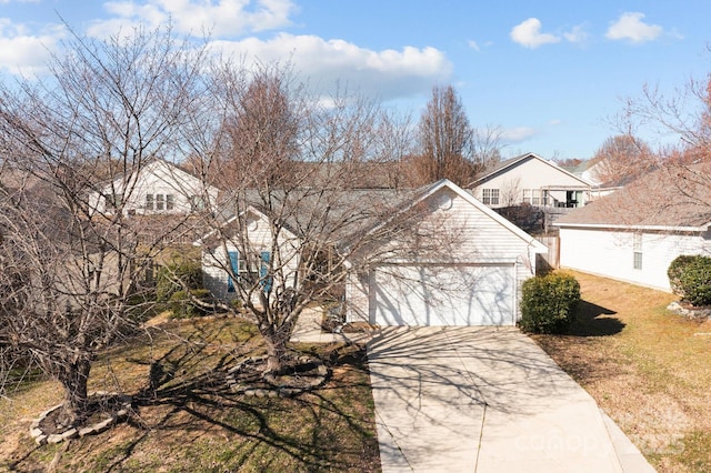 view of front of home featuring a garage, concrete driveway, and a front yard