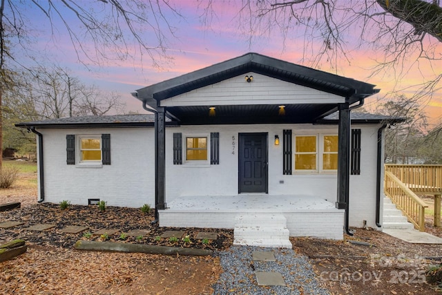 view of front of property featuring brick siding and a porch