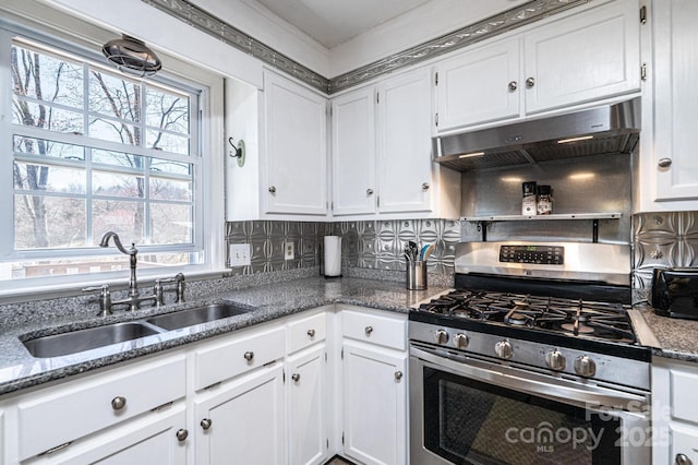 kitchen featuring under cabinet range hood, gas range, white cabinets, and a sink