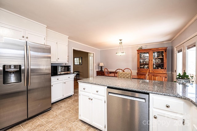 kitchen with dark stone counters, ornamental molding, appliances with stainless steel finishes, white cabinetry, and decorative light fixtures