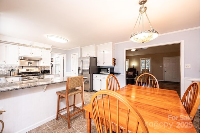 dining space featuring crown molding