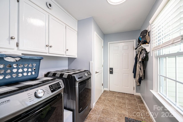 washroom featuring baseboards, cabinet space, and washing machine and clothes dryer