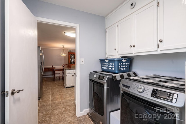 clothes washing area with cabinet space, baseboards, and separate washer and dryer