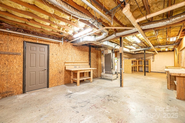 unfinished basement featuring heating unit