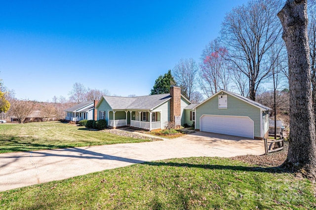 ranch-style home featuring a front lawn, a porch, driveway, an outbuilding, and an attached garage