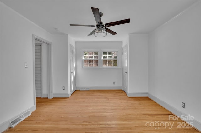 unfurnished room featuring light wood-type flooring, baseboards, visible vents, and ceiling fan