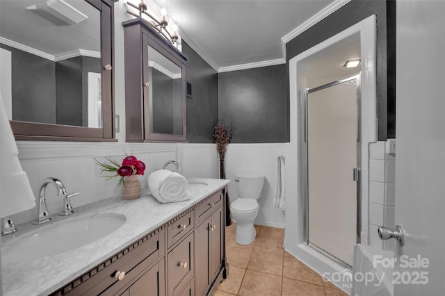 full bath featuring tile patterned floors, crown molding, a wainscoted wall, and a shower stall