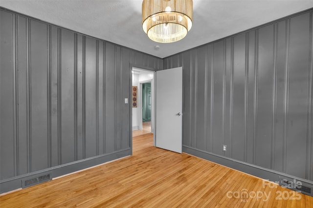 spare room featuring visible vents and wood finished floors