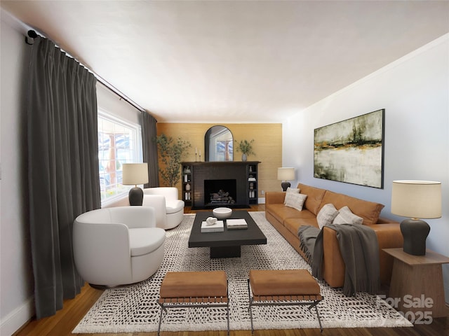 living room featuring a fireplace, crown molding, wood finished floors, and baseboards