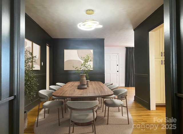 dining space with light wood-style flooring and an inviting chandelier