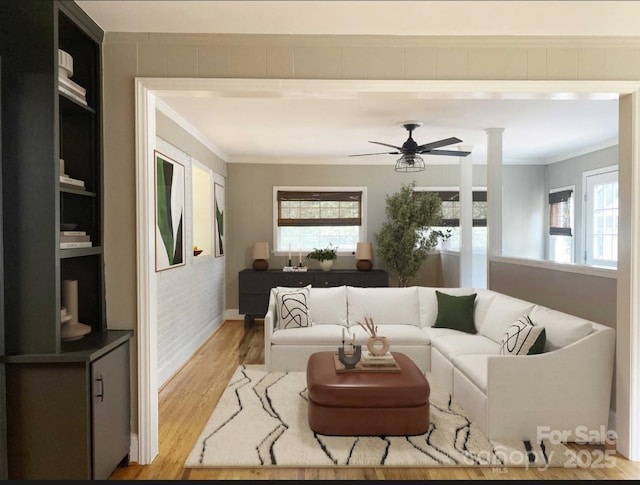 living area featuring light wood-style floors, a healthy amount of sunlight, and crown molding