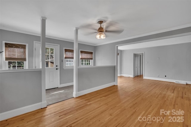 empty room featuring baseboards, a ceiling fan, and wood finished floors