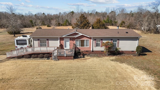 ranch-style home featuring crawl space, a wooden deck, a front lawn, and roof with shingles