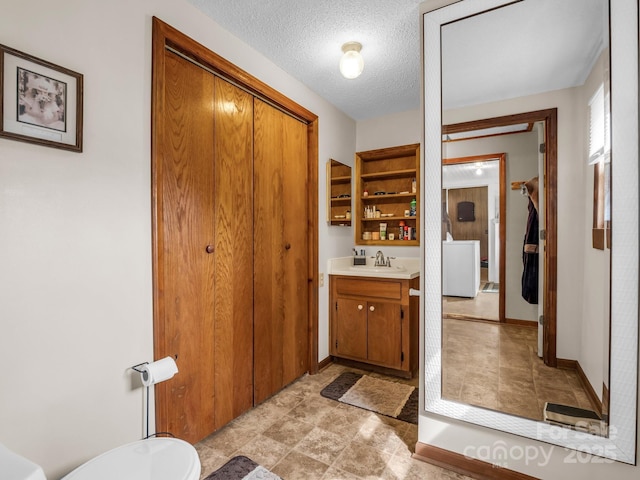 full bathroom with baseboards, a textured ceiling, and vanity