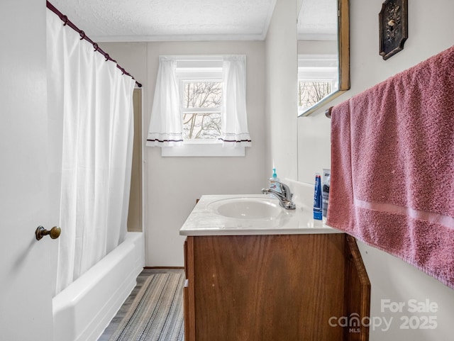 full bath featuring a wealth of natural light, shower / bath combo with shower curtain, a textured ceiling, and vanity