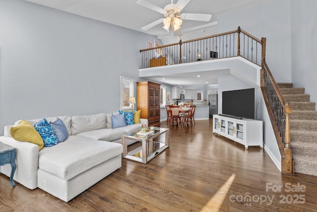 living area featuring stairway, a high ceiling, recessed lighting, dark wood-style flooring, and ceiling fan